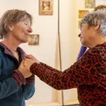 2 senioren met elkaar in verbinding d.m.v. kijken en handen vast