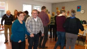 Groep ouderen met dementie die gezamenlijk aan het dansen zijn